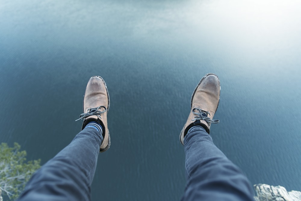 person in blue denim jeans and brown shoes