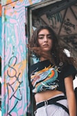woman wearing dragon graphic t-shirt leaning on door frame