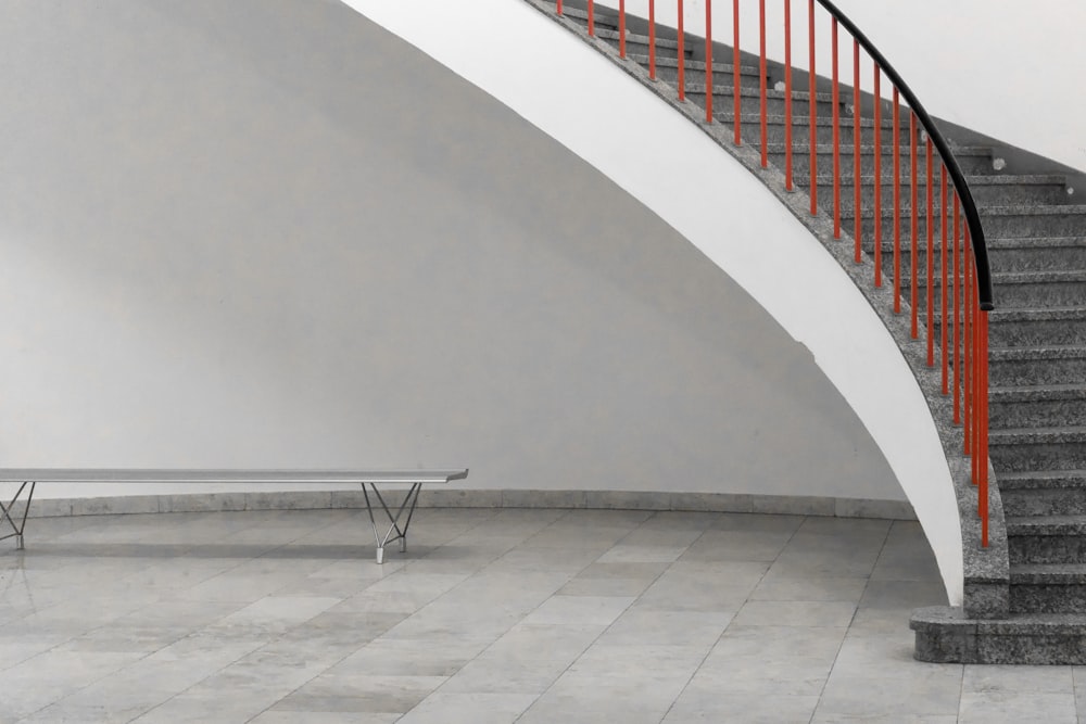 gray steel bench under stairs