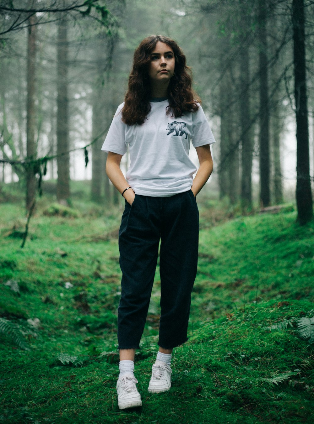 woman standing in middle of forest