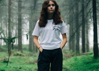 woman standing in middle of forest