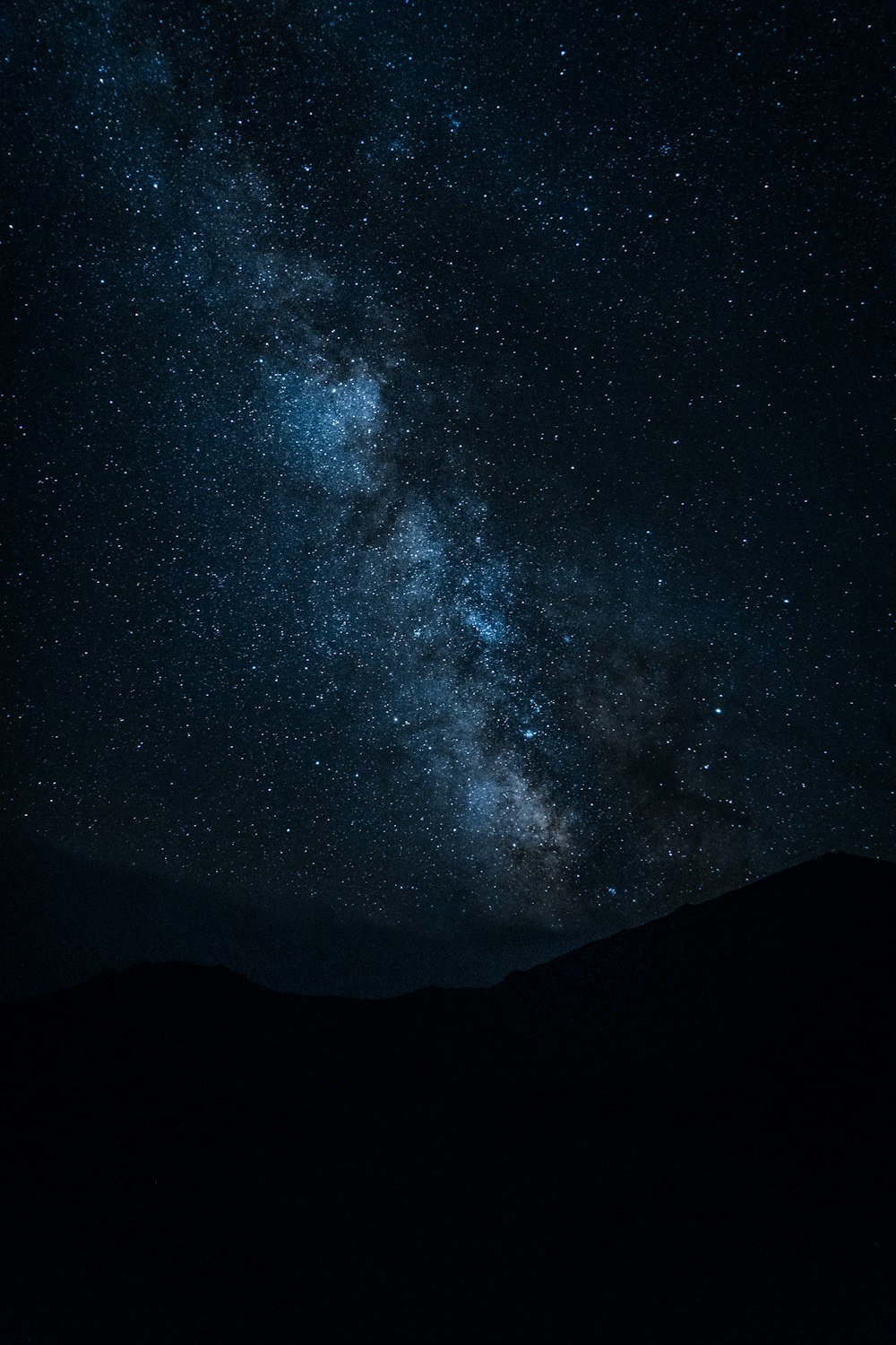 Silueta de la montaña bajo el cielo nocturno estrellado