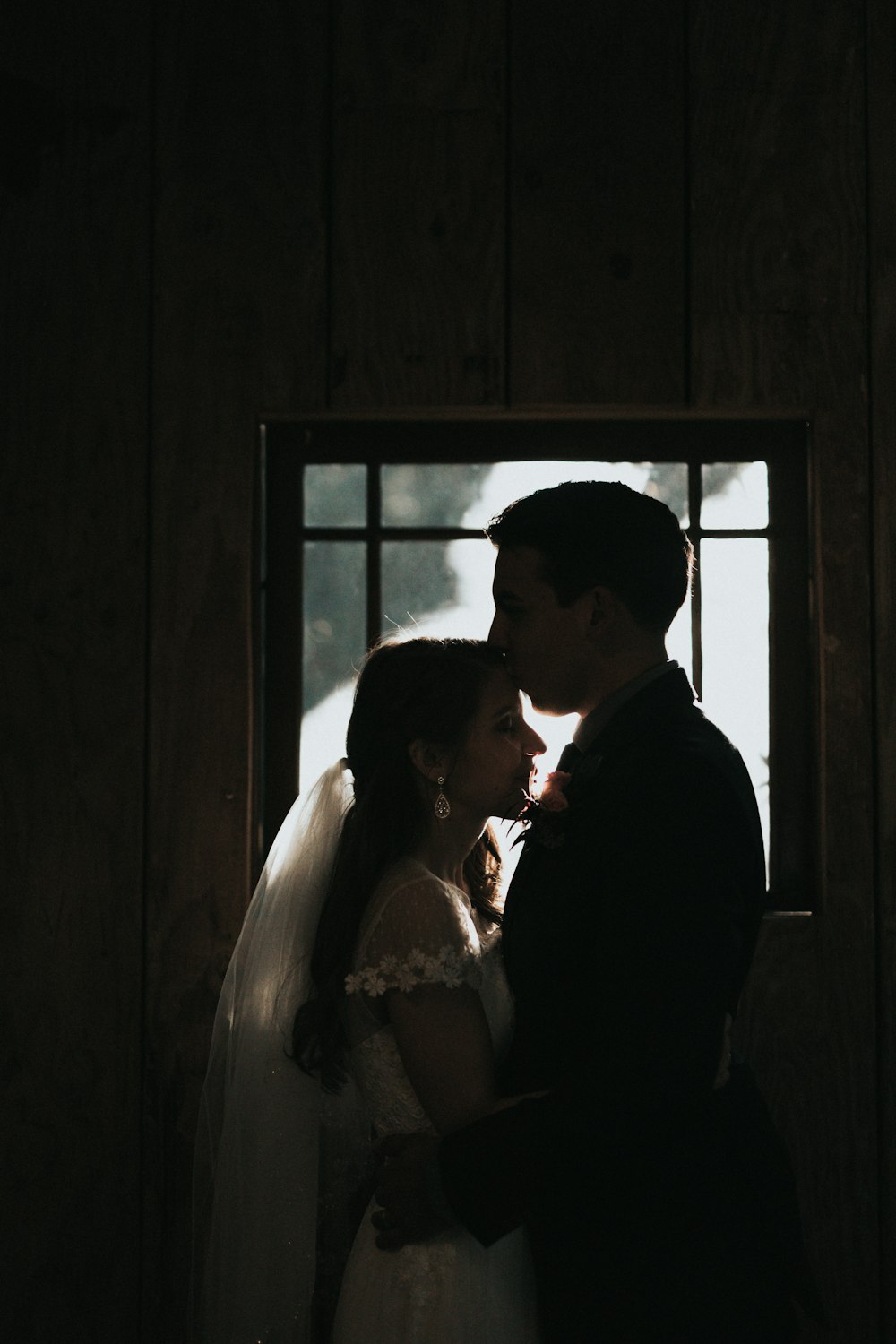 man kissing woman's forehead