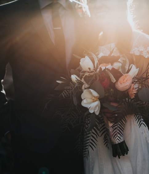 groom beside bride holding bouquet flowers