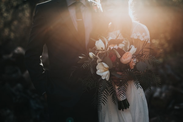 groom beside bride holding bouquet flowers