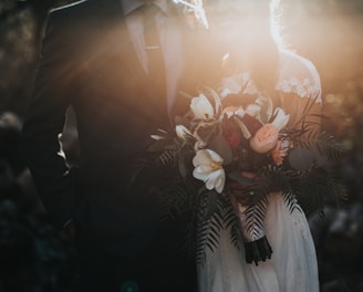 groom beside bride holding bouquet flowers