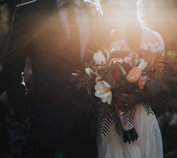 groom beside bride holding bouquet flowers