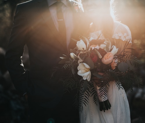 groom beside bride holding bouquet flowers