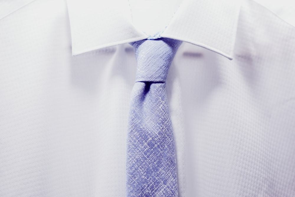 青いネクタイと白い襟付きシャツをクローズアップする写真