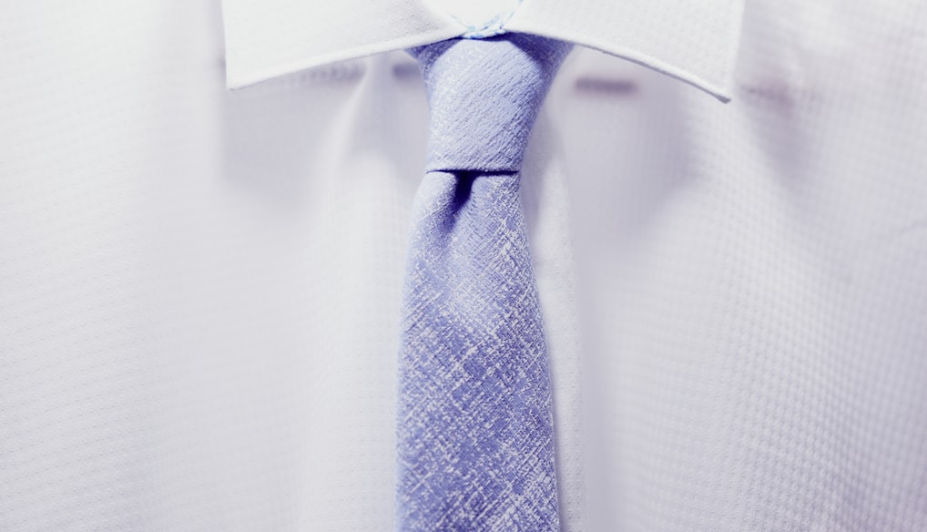 close up photo white collared shirt with blue necktie