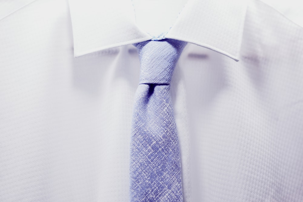 close up photo white collared shirt with blue necktie