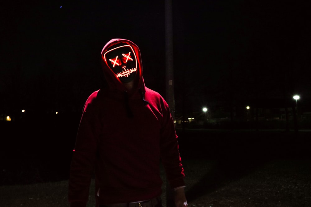 person wearing black mask standing near post