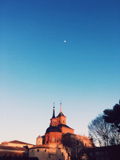 A warm, inviting photo of the historic Syracuse Bible Chapel building bathed in soft morning light.