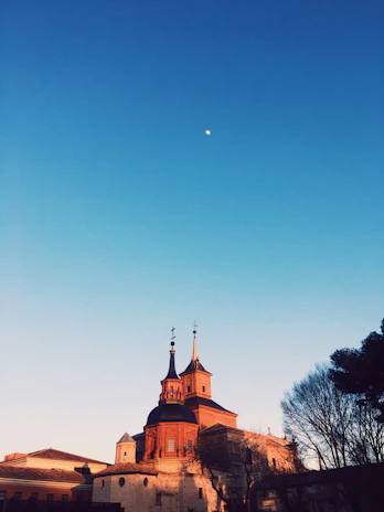 A warm, inviting photo of the historic Syracuse Bible Chapel building bathed in soft morning light.