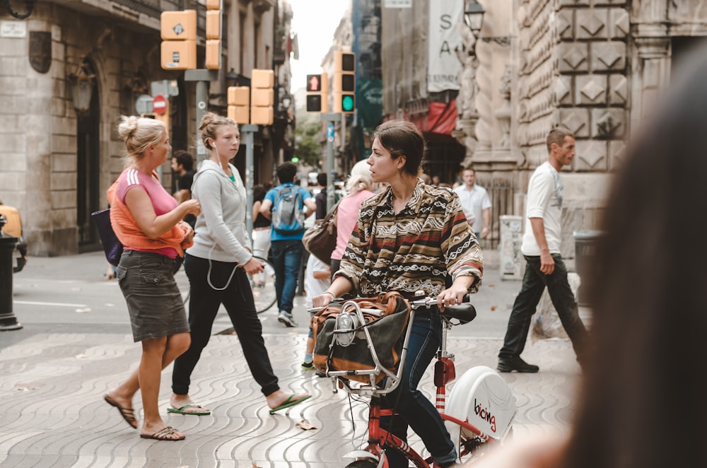 woman in black jeans riding on bicycle