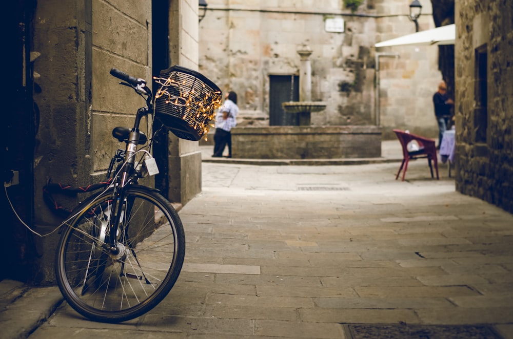 Bicicleta negra al lado de la puerta de madera