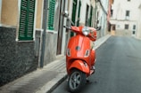 red motor scooter on street during day time