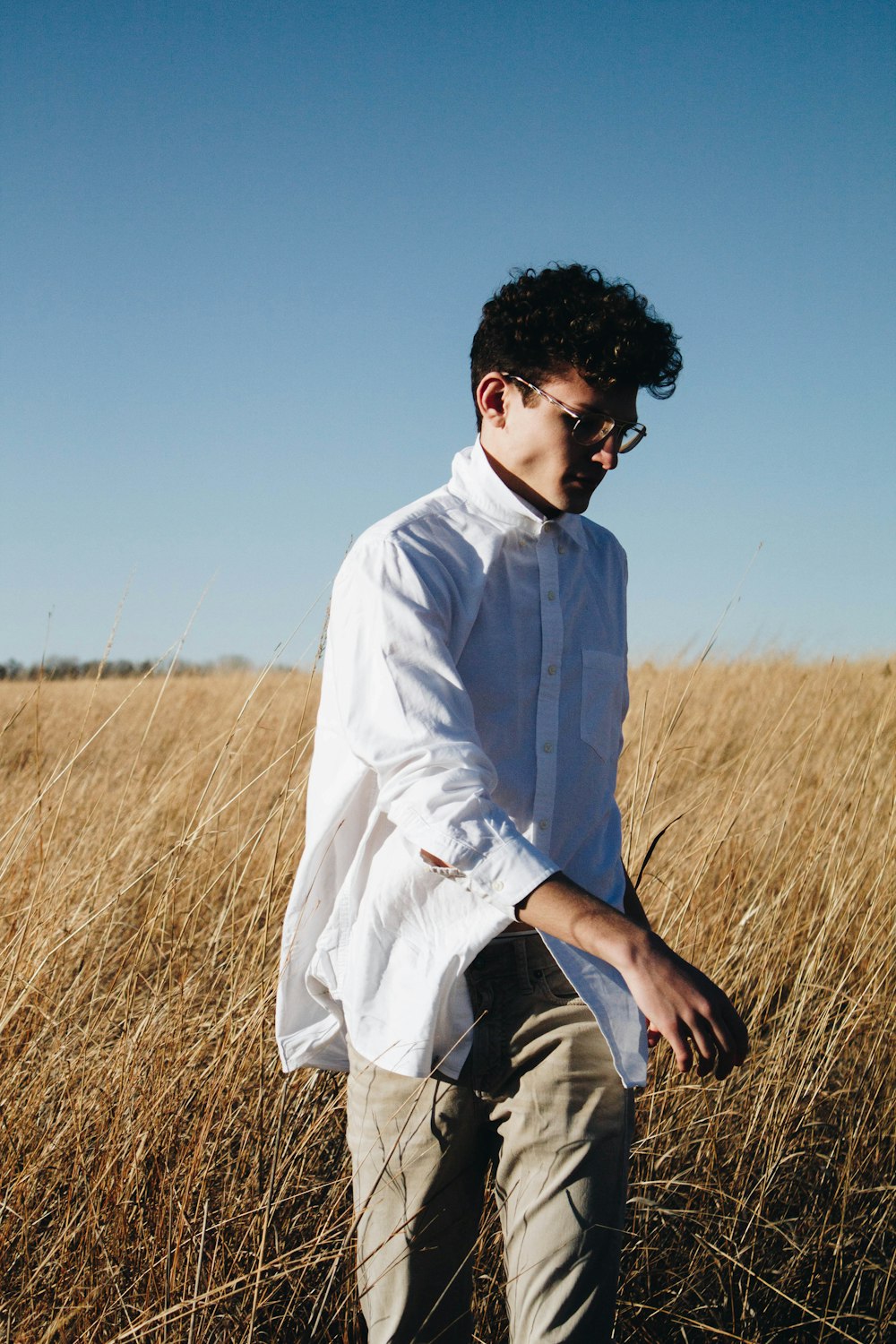 man walking on brown grass during blue sky