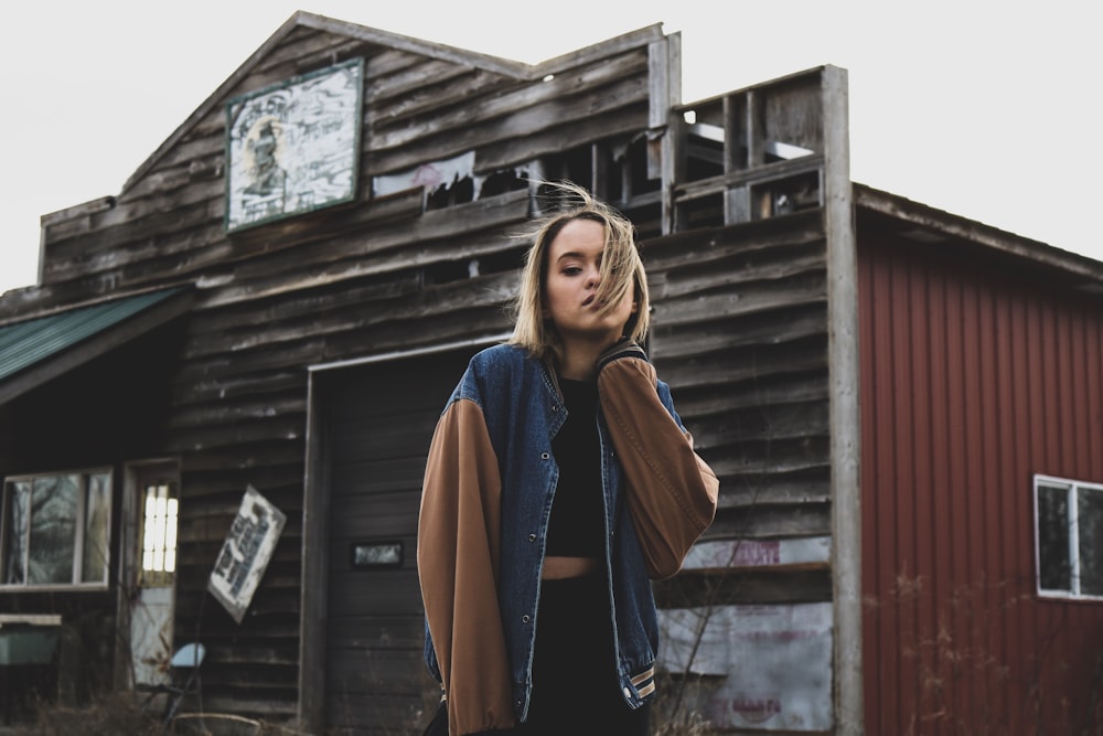 woman holding her neck in front of barn