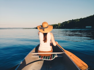 Close-up of a guide helping a person with a disability enjoy adaptive canoeing on a sunny day.