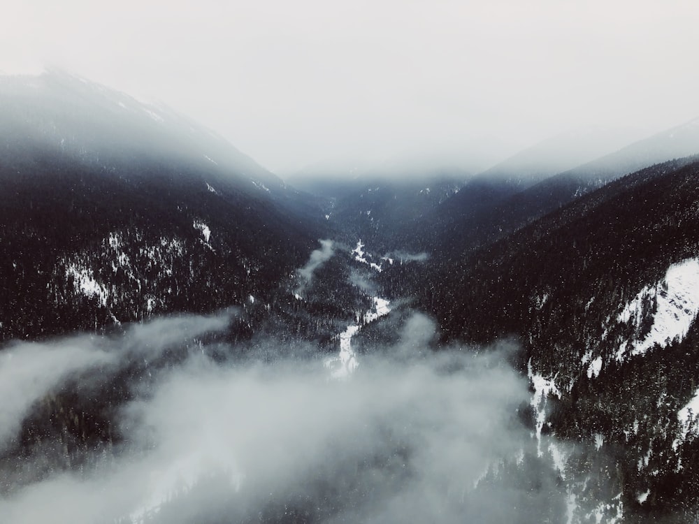 Photographie aérienne d’une chaîne de montagnes recouverte de brouillards