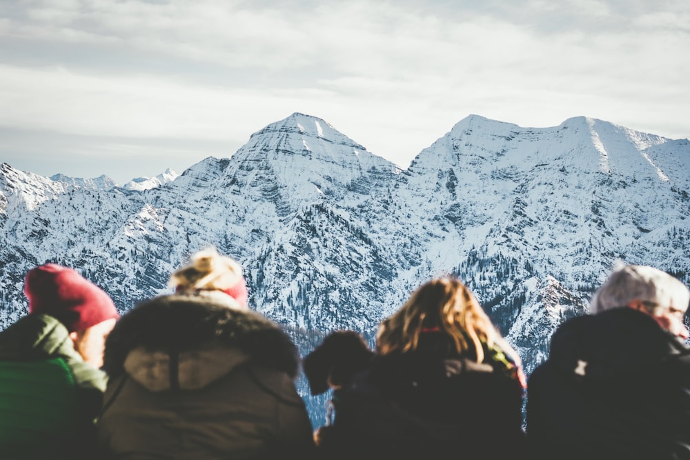 four people viewing snowy mountain during daytime