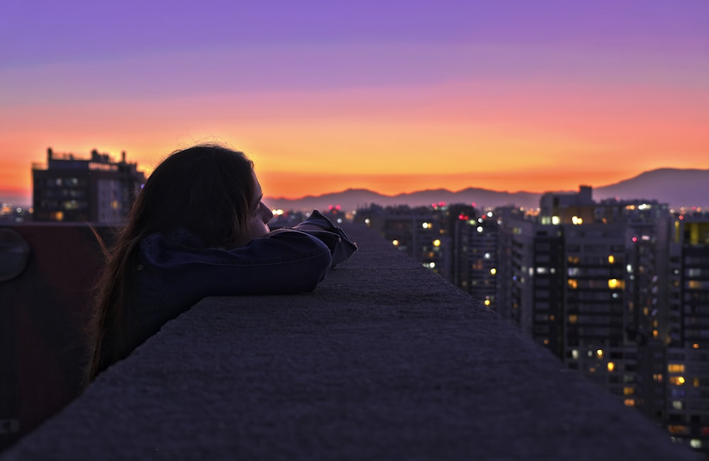 woman standing on roof while looking on buildig