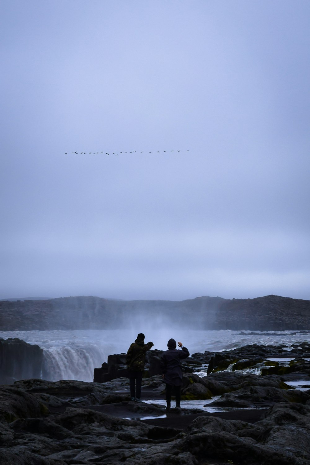 silhouette of two men on rock formation