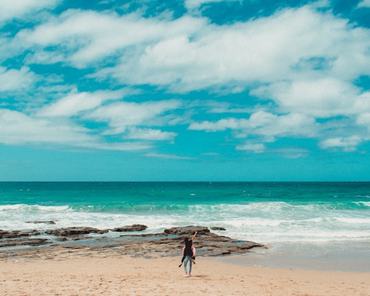 person carrying another person on the back on the beach in Great Ocean Road Australia