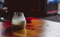 Close-up of creamy dairy products in glass jars with natural wooden background.