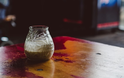 Rustic jars filled with golden ghee on wooden table