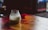 Close-up of a golden jar of traditional ghee with a wooden spoon on a rustic wooden table.