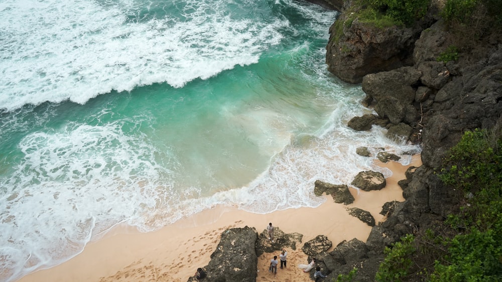 ocean waves on shore beside mountain