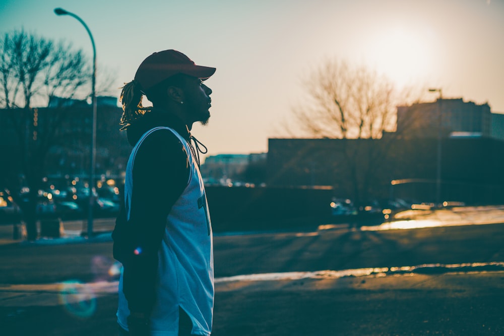 side view of man wearing white tank top during golden hour