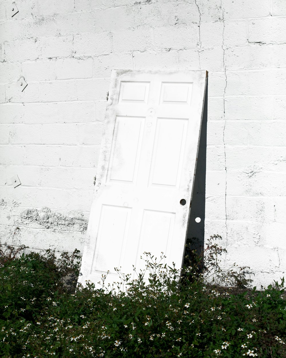 白い壁に吊るされた白い木製のドア