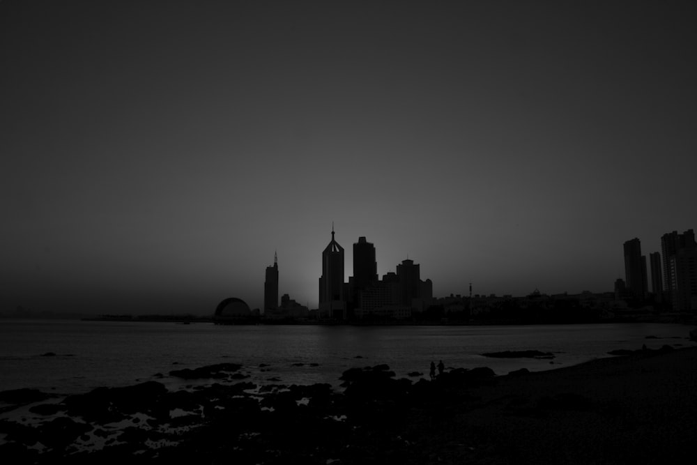 silhouette of buildings near body of water