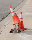two traffic cones on gray road