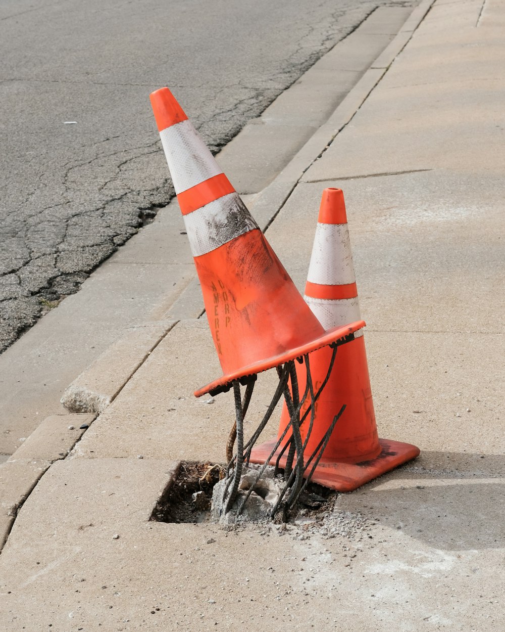 two traffic cones on gray road