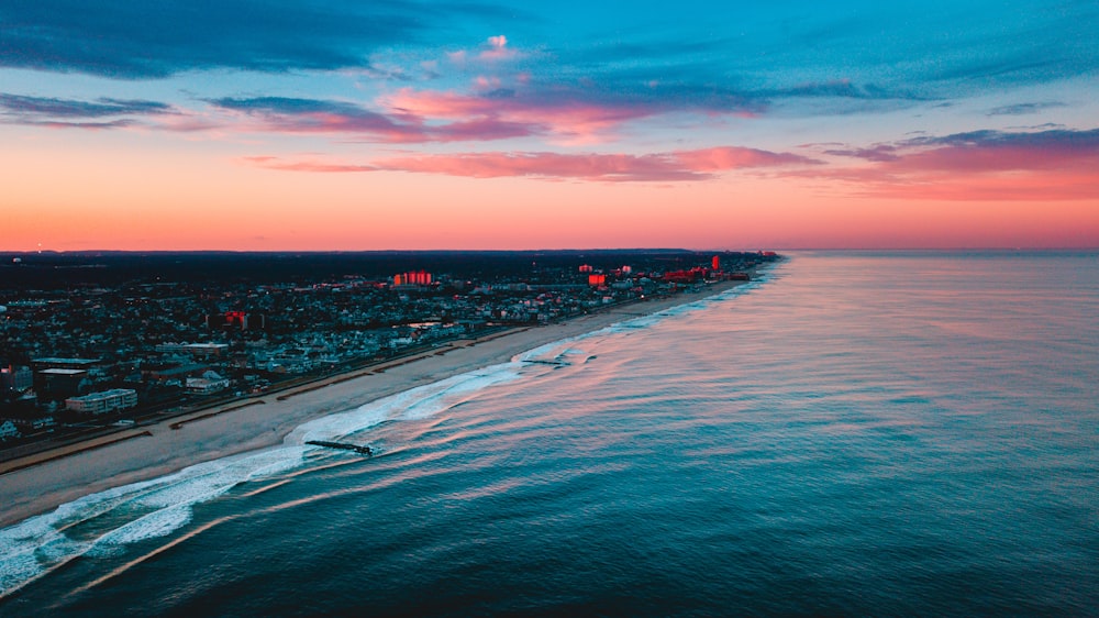 aerial photography of buildings near ocean during golden hour