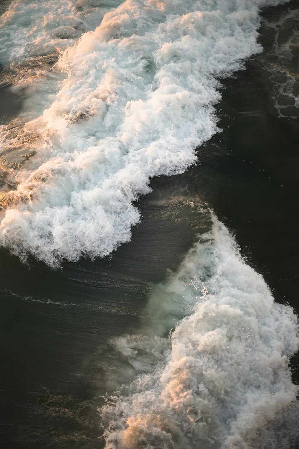 waves crashing on shore in aerial photography