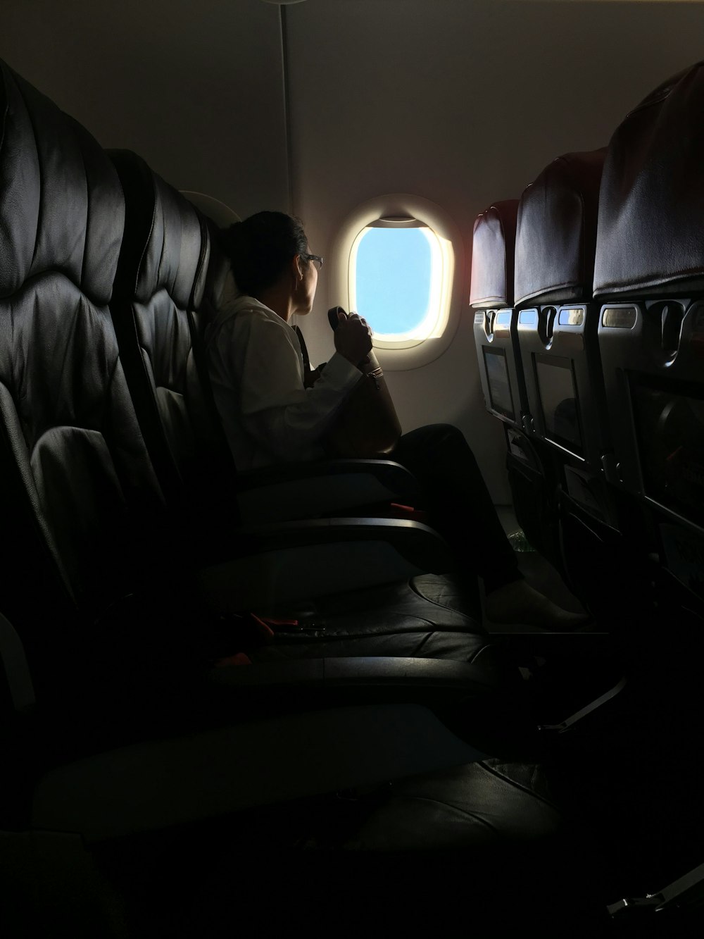person sitting on plane watching the window