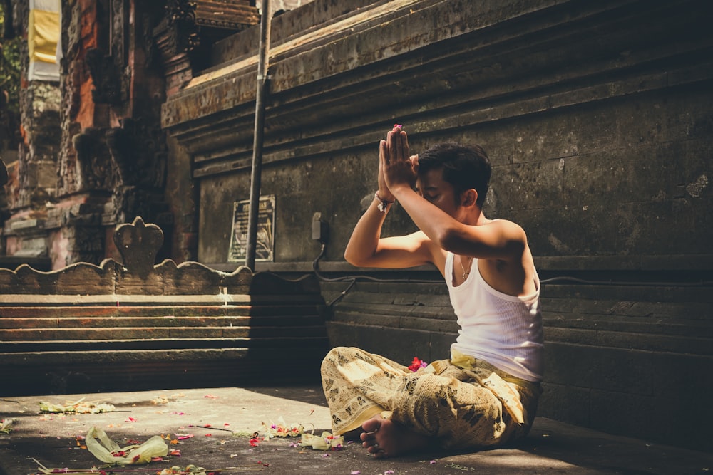 man in white tank top praying