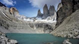 gray rocky mountain across body of water at daytime