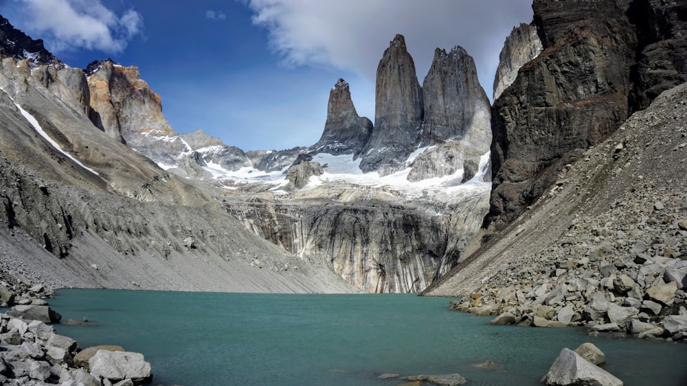 gray rocky mountain across body of water at daytime