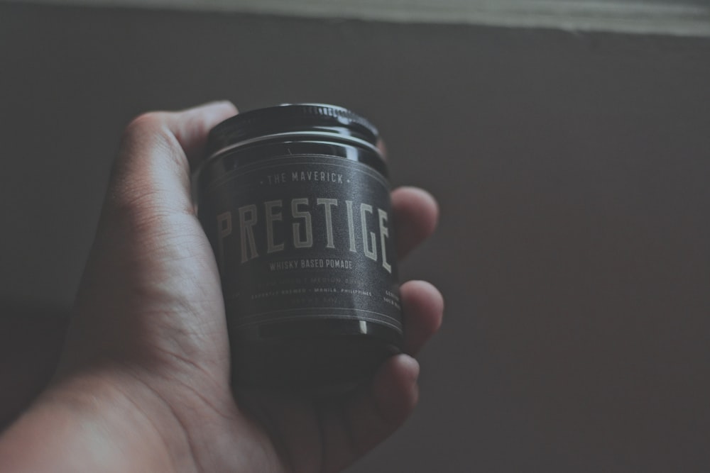 person holding Prestige bottle