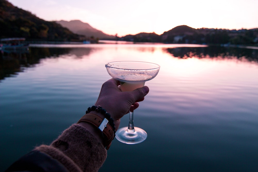 personne tenant un verre à cocktail