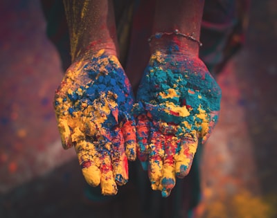 closeup photo of person holding color soils deepavali teams background