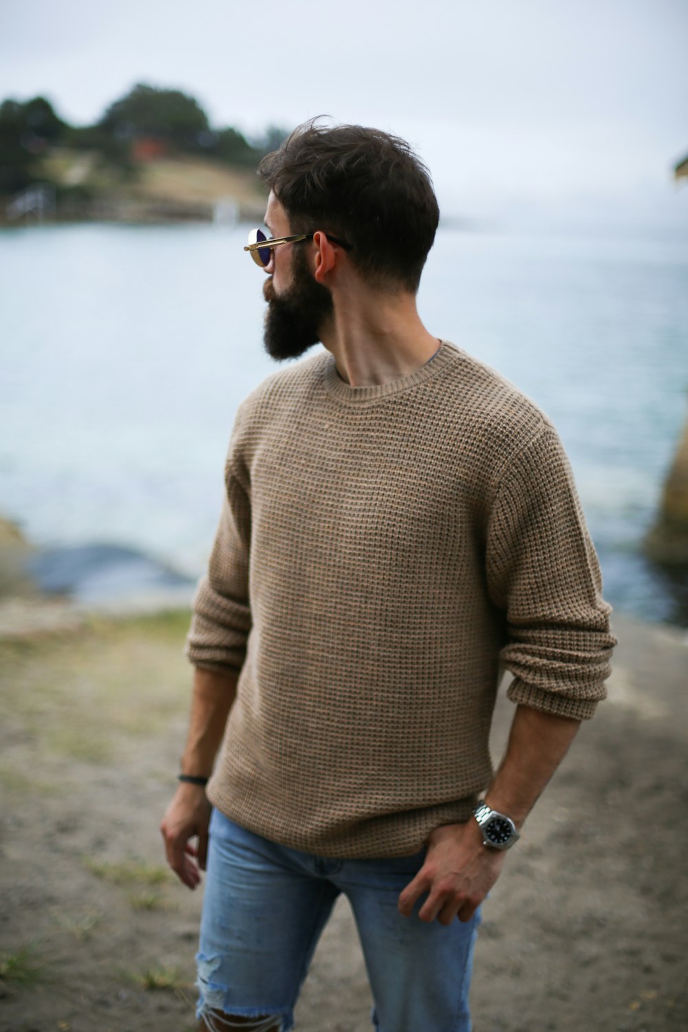 uomo in maglione lavorato a maglia marrone vicino alla spiaggia