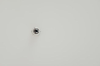 A compact surveillance camera mounted on a wall with clear focus.