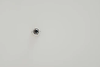 Compact 4K PTZ camera mounted on a conference room wall.
